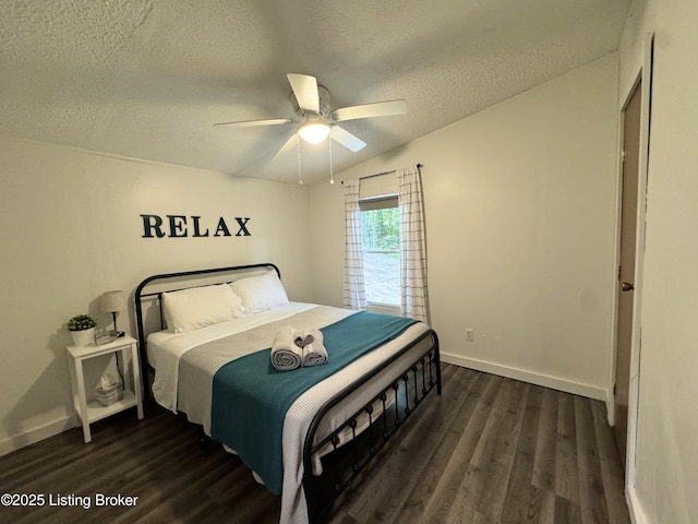 bedroom with a ceiling fan, a textured ceiling, baseboards, dark wood-style flooring, and vaulted ceiling