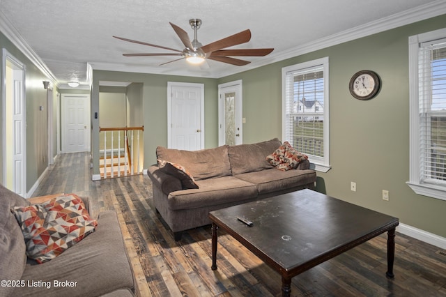 living room with crown molding, wood finished floors, baseboards, and ceiling fan