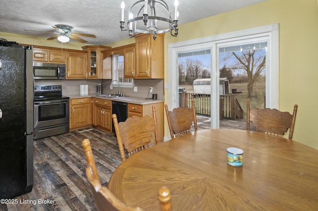 kitchen with light countertops, stainless steel appliances, dark wood-style floors, a textured ceiling, and a sink