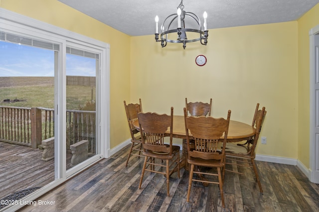 dining space featuring baseboards, an inviting chandelier, and wood finished floors