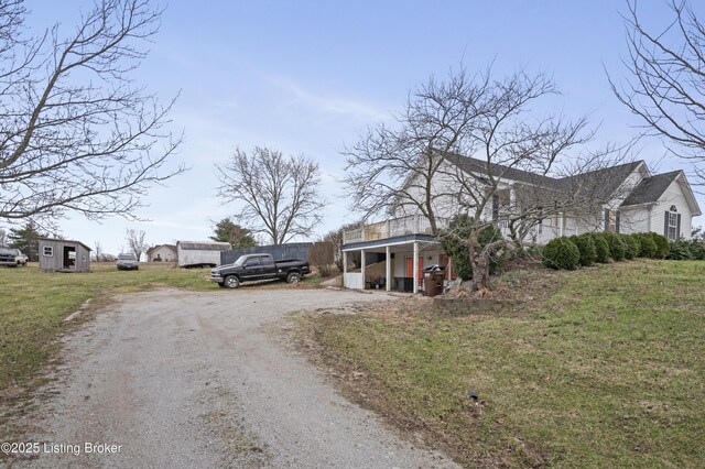 view of front of house featuring a front lawn and dirt driveway