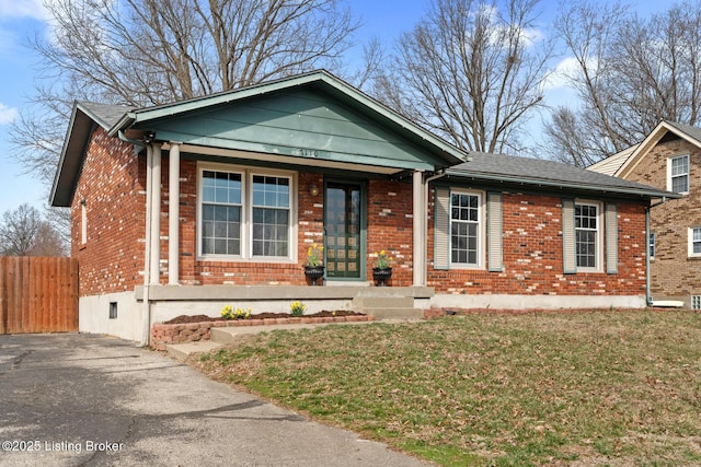 view of front facade with a front yard, a porch, fence, and brick siding