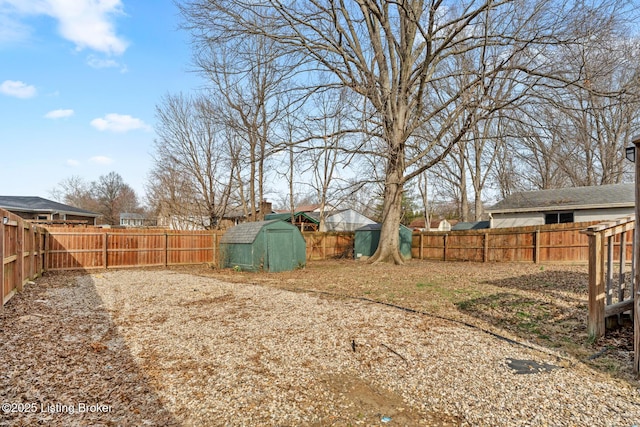 view of yard featuring a storage unit, an outbuilding, and a fenced backyard