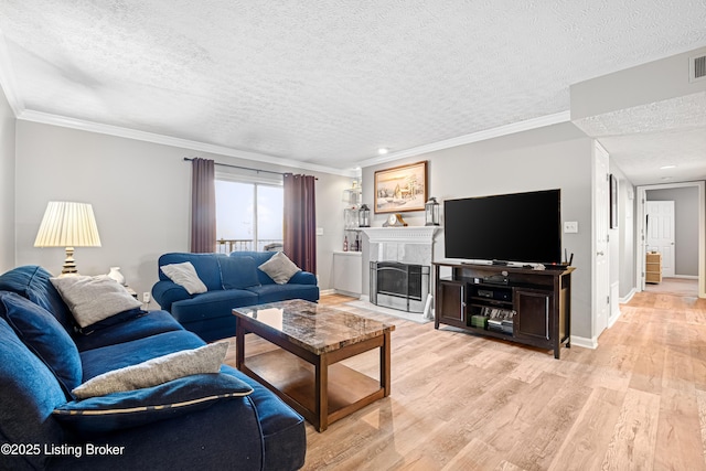 living room featuring baseboards, a textured ceiling, light wood-style floors, and ornamental molding