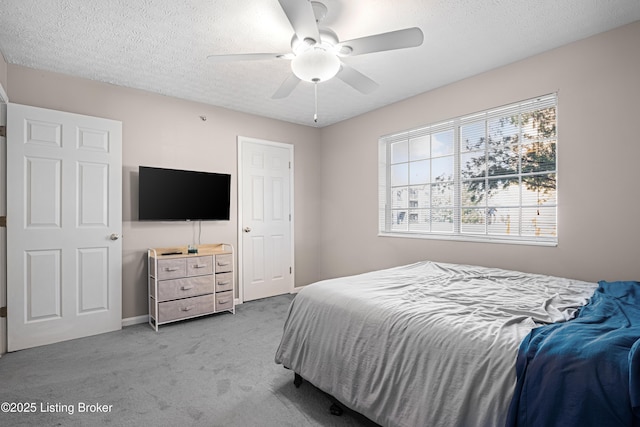 bedroom featuring light carpet, a textured ceiling, and a ceiling fan