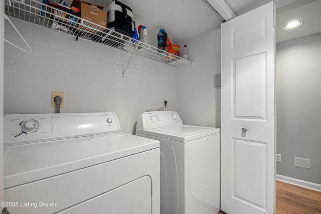 clothes washing area featuring laundry area, light wood-type flooring, visible vents, and washing machine and clothes dryer