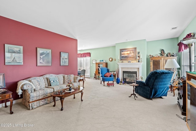 living room with a glass covered fireplace, carpet flooring, baseboards, and visible vents