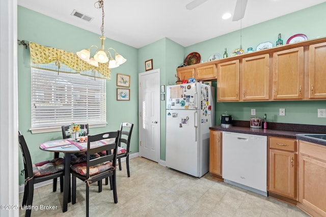 kitchen featuring white appliances, visible vents, hanging light fixtures, dark countertops, and ceiling fan with notable chandelier