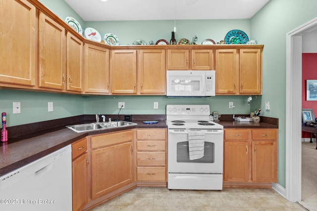 kitchen featuring a sink, white appliances, dark countertops, and light tile patterned flooring