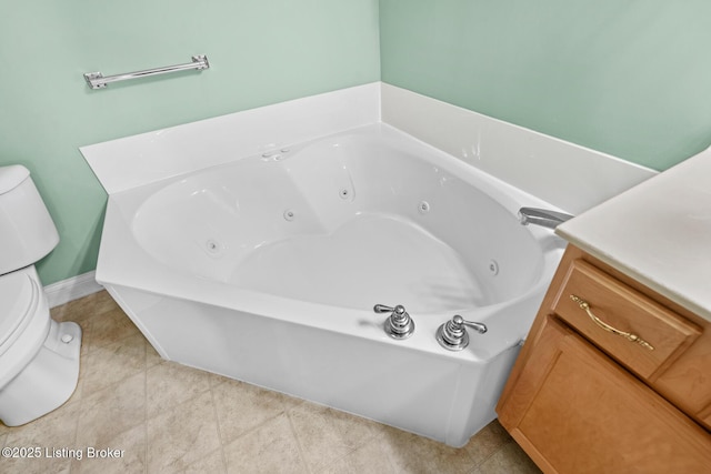 full bath with tile patterned floors, toilet, and a tub with jets