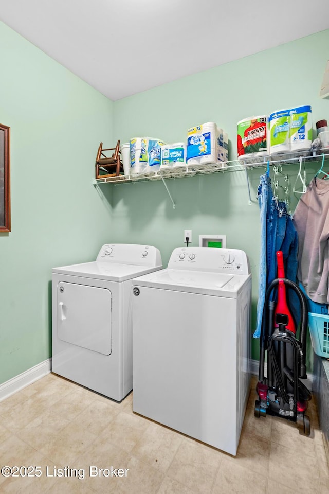 clothes washing area with washing machine and clothes dryer, laundry area, and baseboards