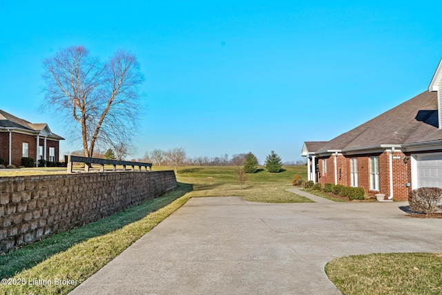 view of yard featuring an attached garage and driveway