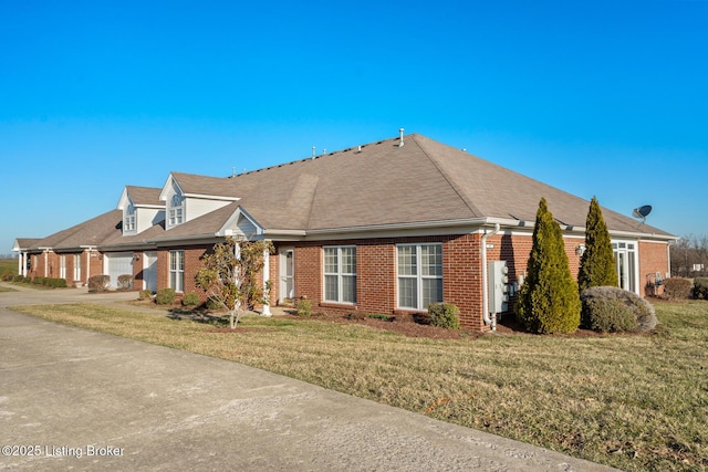 view of front of property with brick siding, concrete driveway, and a front lawn