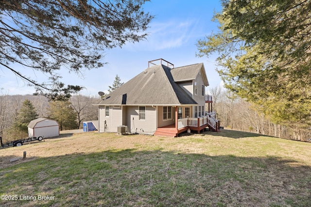 rear view of property with a wooden deck, a yard, central AC, an outdoor structure, and a storage unit