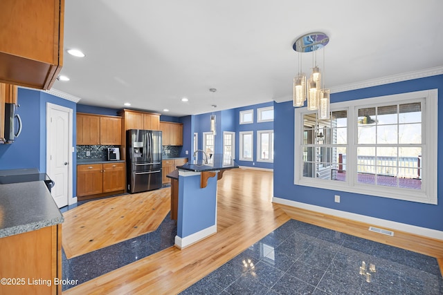 kitchen with granite finish floor, visible vents, stainless steel appliances, and baseboards