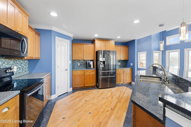 kitchen featuring recessed lighting, a sink, black range with electric stovetop, decorative light fixtures, and stainless steel fridge