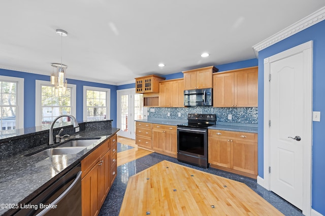 kitchen with a sink, decorative backsplash, appliances with stainless steel finishes, and a wealth of natural light