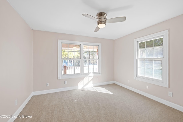 unfurnished room featuring a healthy amount of sunlight, baseboards, and carpet