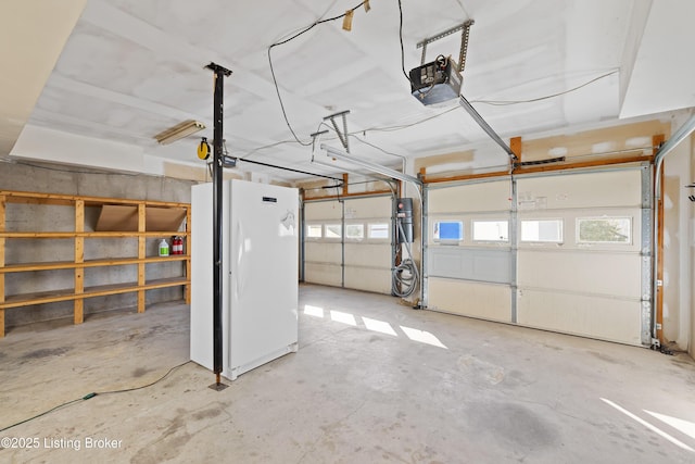 garage featuring a garage door opener and freestanding refrigerator