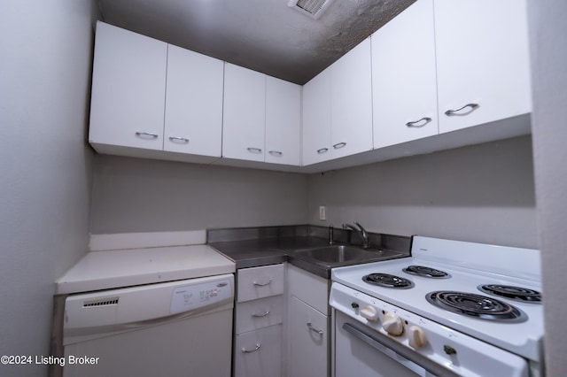 kitchen featuring white appliances, white cabinets, visible vents, and a sink