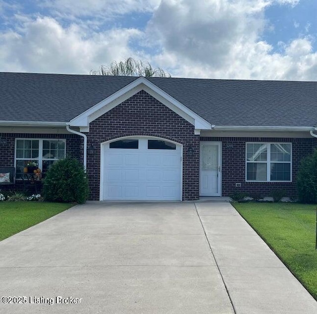 ranch-style home with concrete driveway, a front yard, a shingled roof, a garage, and brick siding