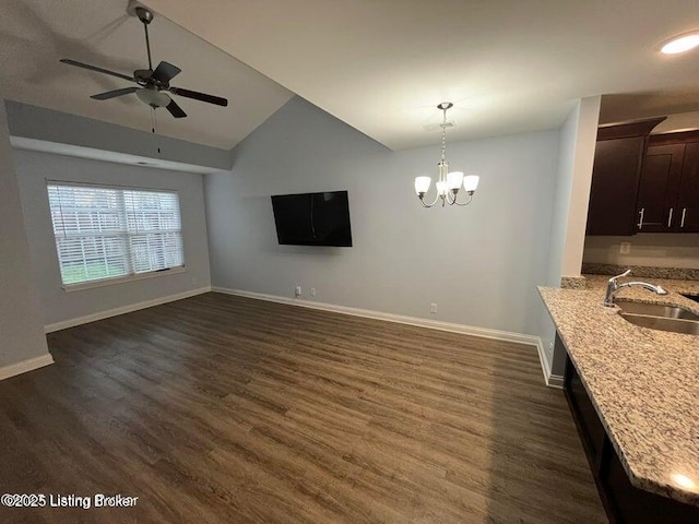 unfurnished dining area with a sink, baseboards, dark wood-type flooring, and vaulted ceiling