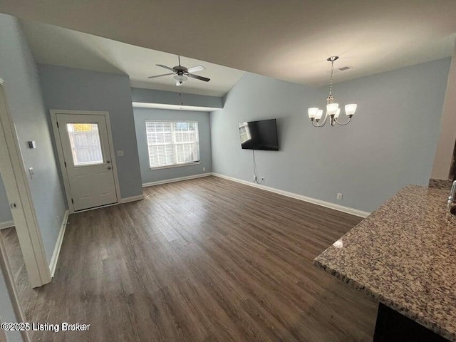 unfurnished living room with baseboards, dark wood finished floors, vaulted ceiling, and ceiling fan with notable chandelier