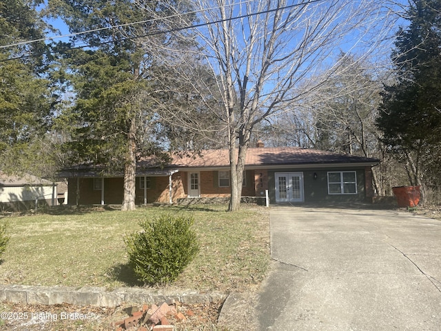 single story home featuring a front yard, french doors, and driveway