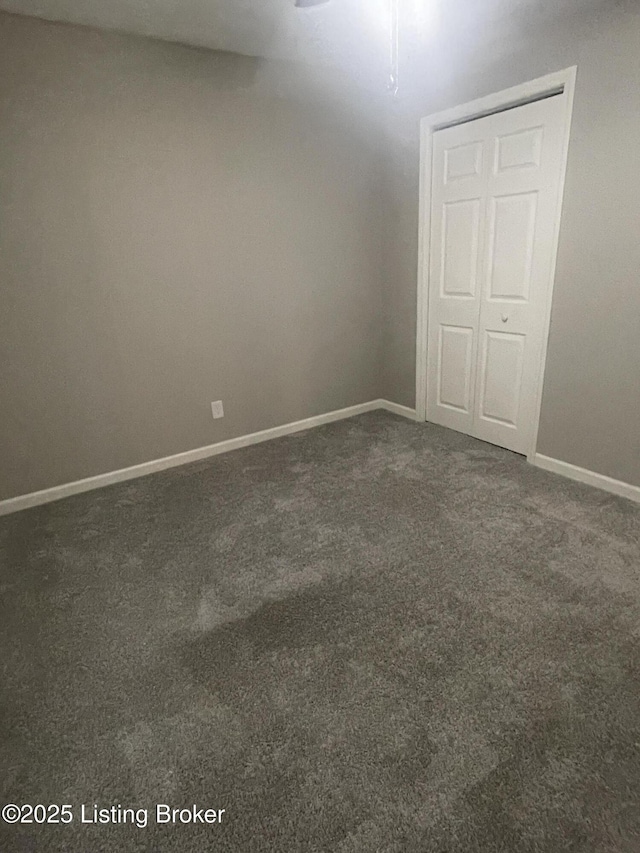 empty room featuring baseboards and carpet