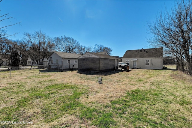 rear view of house with a lawn and a fenced backyard