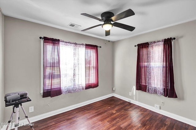 interior space with visible vents, a ceiling fan, baseboards, and wood finished floors