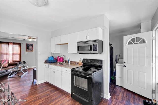 kitchen with stainless steel microwave, black range with electric cooktop, washer / dryer, dark wood-style floors, and a sink