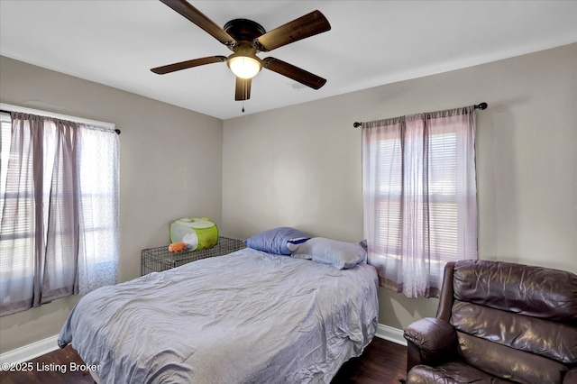 bedroom featuring ceiling fan, baseboards, and wood finished floors