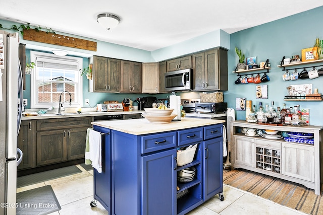 221 Forrest Dr, Lawrenceburg, KY 40342 - kitchen featuring appliances with stainless steel finishes, light countertops, a sink, open shelves, and a kitchen island
