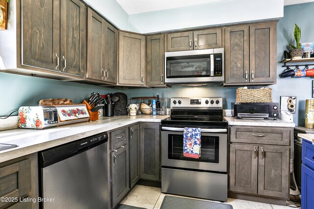 221 Forrest Dr, Lawrenceburg, KY 40342 - kitchen featuring stainless steel appliances, light tile patterned floors, and dark brown cabinetry