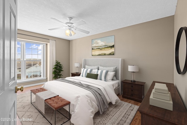 bedroom featuring a textured ceiling, ceiling fan, and wood finished floors