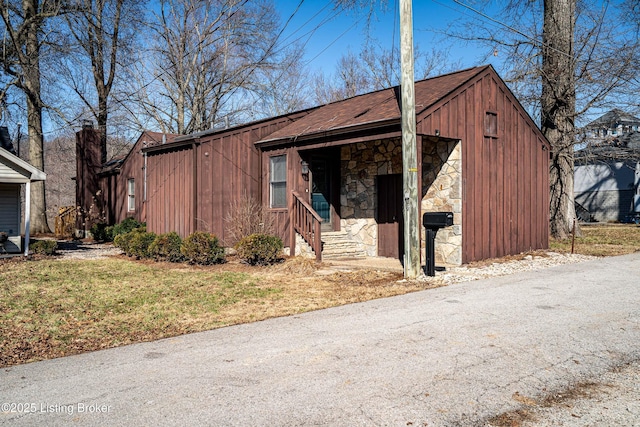 view of front of property with stone siding, board and batten siding, and a detached garage