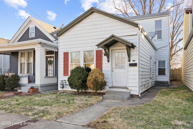 view of front of property with fence, covered porch, a front yard, and entry steps