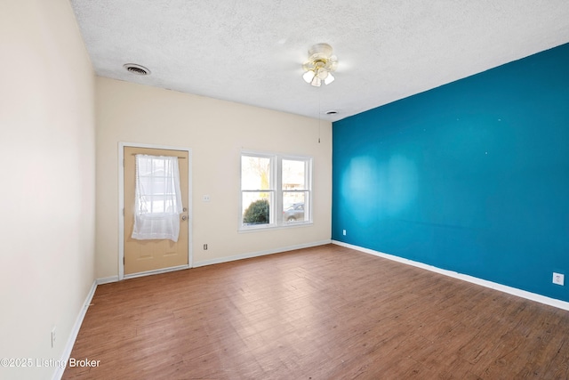 spare room featuring plenty of natural light, wood finished floors, and ceiling fan