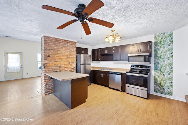 kitchen with light wood-style flooring, a sink, light countertops, dark brown cabinets, and appliances with stainless steel finishes