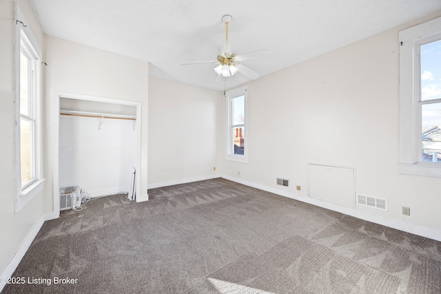 unfurnished bedroom featuring visible vents, baseboards, carpet flooring, a closet, and a ceiling fan