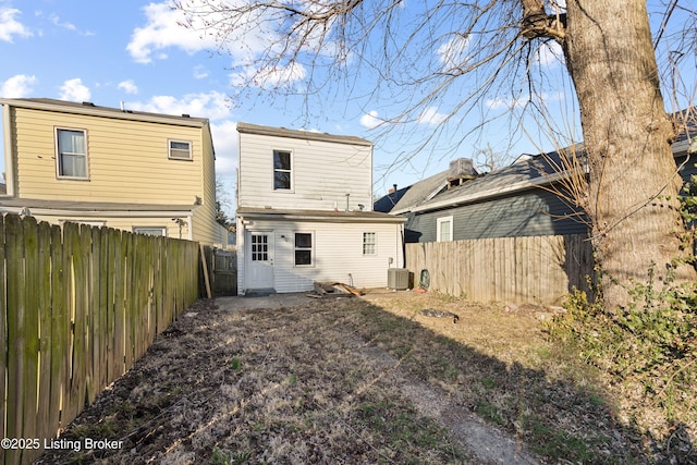 rear view of property with central AC and a fenced backyard