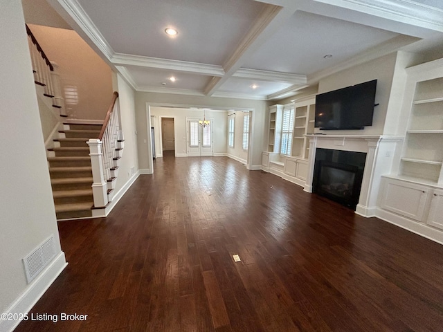 unfurnished living room with visible vents, dark wood-style flooring, coffered ceiling, an inviting chandelier, and stairs