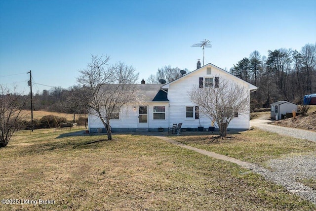 back of house featuring a yard and a chimney