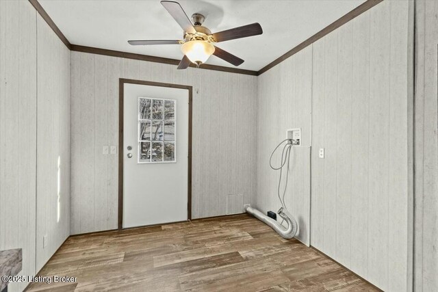 clothes washing area featuring washer hookup, wood finished floors, laundry area, and crown molding