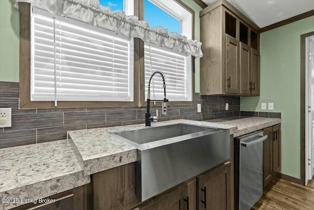 kitchen featuring tasteful backsplash, a healthy amount of sunlight, wood finished floors, and a sink