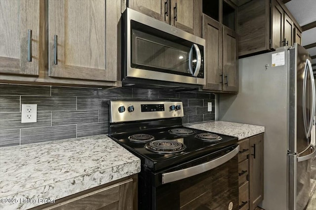 kitchen featuring dark brown cabinetry, backsplash, and stainless steel appliances