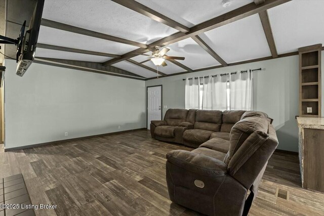 living area featuring baseboards, vaulted ceiling with beams, dark wood-style flooring, and a ceiling fan