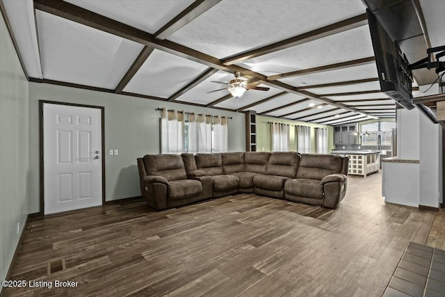 living room with plenty of natural light, lofted ceiling with beams, a ceiling fan, and wood finished floors