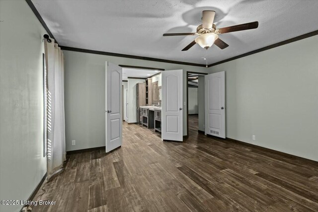 unfurnished bedroom featuring ceiling fan, dark wood-type flooring, baseboards, and ornamental molding